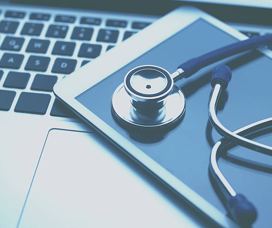 Image of a tablet and stethoscope on a laptop