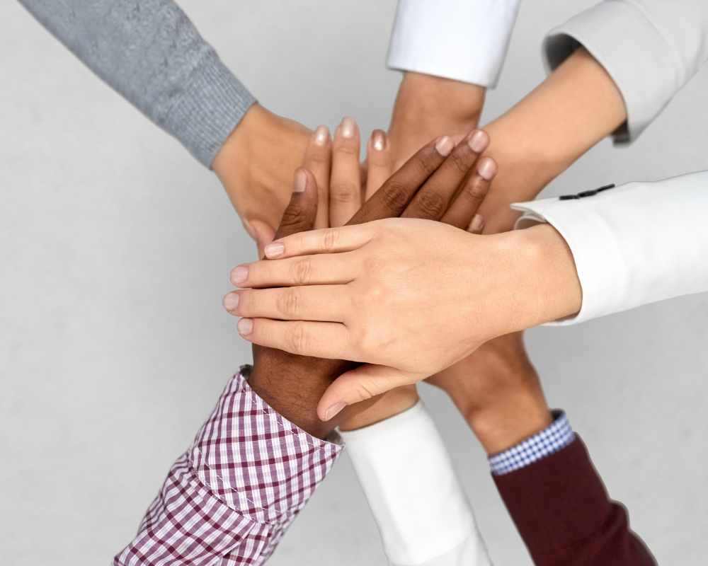 Image of various employees' hands on top of each other